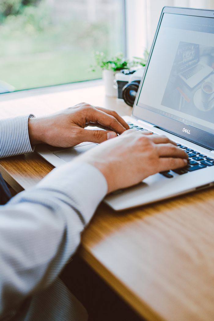 A man at work on a laptop in a contemporary office environment.